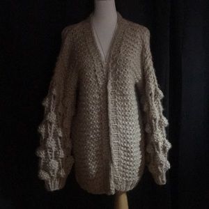 This is a snuggly chunky cardigan Pom Pom sleeves.